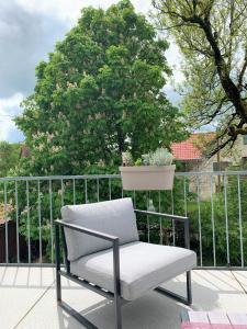 梅明根Fe Wo Brunnen - 120 qm- ruhige Lage - viel Natur - komfortabel - grosser Balkon und Garten的阳台的椅子,种植了盆栽植物