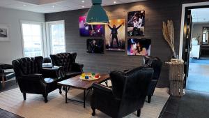 Furuvik Havshotell的一间设有椅子和一张桌子的等候室,墙上挂着图片