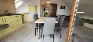 波别罗沃Kama Pobierowo 2的厨房配有黄色橱柜和桌椅