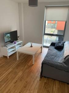 利物浦Liverpool City Centre Apartment的客厅配有床、桌子和电视