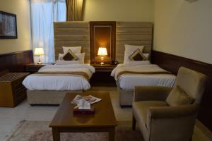 拉合尔Al Nafoura Hotel的酒店客房,设有两张床和一张沙发