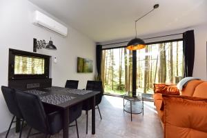 Luokesos SenPremium Forest Bungalow with Ofuro Tub的一间用餐室,配有黑色的桌子和椅子