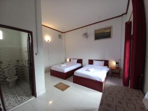 孟丰沙湾Sipanya Guesthouse的客房设有两张床和一间带卫生间的浴室。