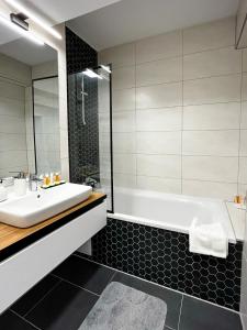 布拉索夫Alegria Avantgarden Brasov的浴室配有白色水槽和浴缸。