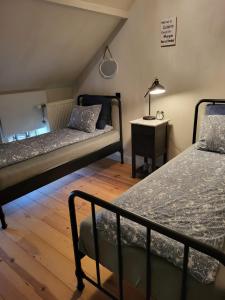OpglabbeekWelness gastenverblijf Carpe Diem的一间卧室配有两张床和一张带台灯的桌子