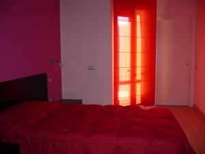 圣安蒂奥科伊科罗利酒店的红色的房间,设有床和窗户