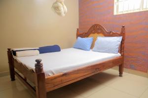 坎帕拉Perfect Motel的一张带蓝色和白色枕头的木床
