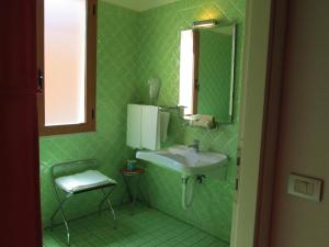 圣安蒂奥科伊科罗利酒店的绿色浴室设有水槽和镜子