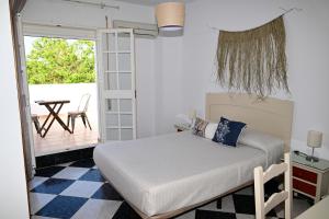 科尼尔-德拉弗龙特拉罗萨莱斯旅馆的一间卧室配有一张床,阳台配有桌子