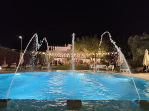 蒙塔尔巴诺马塞里亚安雪拉酒店的一座建筑前的带喷泉的游泳池