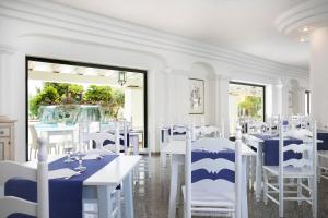 奥罗塞伊玛丽娅罗萨日亚酒店的用餐室配有白色的桌子和白色的椅子
