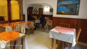 圣卡洛斯-德巴里洛切苏尔旅馆的一间设有桌椅的餐厅,有坐在桌子上的人