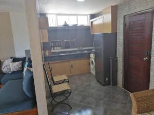 米迪克House near beach的厨房配有黑色冰箱和沙发。