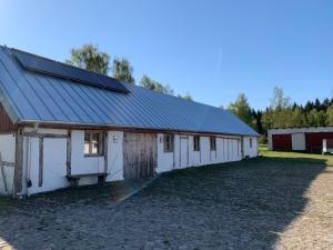 SjöboNavröds Gård的一座白色谷仓,上面设有太阳能电池板