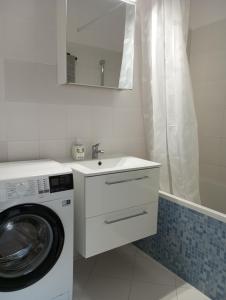 索波特BrodWino的白色的浴室设有洗衣机和水槽。