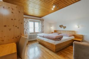 Gurtis伯格霍夫莱泽酒店的一间卧室设有一张床和木制天花板