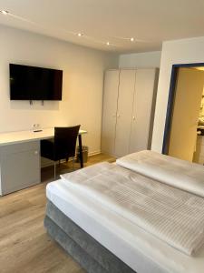 维特利希温特赫尔酒店的一间卧室配有两张床、一张桌子和一台电视。