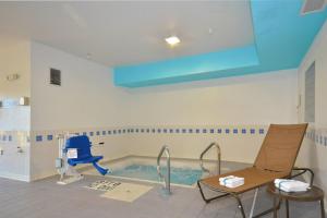 斯普林菲尔德Spark by Hilton Springfield Southwest的一个带蓝色椅子的房间的游泳池