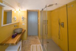 奥斯图尼Ostuni Art Resort的一间带水槽和玻璃淋浴的浴室