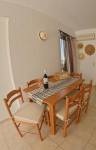 马克里亚罗斯Manos Seaside Apartment的餐桌和椅子,上面有一瓶葡萄酒