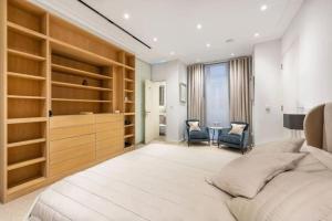 伦敦Stunning Mayfair 3 bed flat with terrace and fireplace的一间卧室配有一张带木制架子的大床