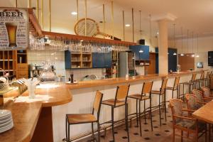 格拉茨CenterCourt Hotel的餐厅设有酒吧,配有木凳
