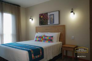 皮雷诺波利斯Resort Quinta Santa Bárbara OFICIAL的一间卧室配有床、窗户和床罩。