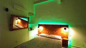 科拉托B&B Santa Rita Corato的一间卧室配有一张绿灯床