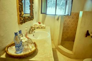 瓦塔穆Mvuvi Lodge的一间带水槽和镜子的浴室