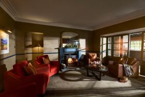 汤格唐古酒店的客厅配有2把红色椅子和壁炉