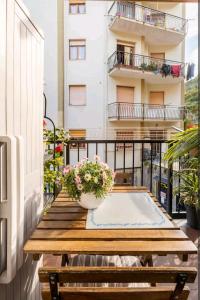 拉帕洛Camera privata nell'appartamento in zona residenziale con 2 piscine的阳台配有木桌和鲜花。