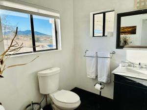 约书亚树Ravens Nest Ranch, Fire pit , Views, Near JT Park!的一间带卫生间、水槽和窗户的浴室