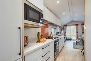 巴森斯韦特Elite Holiday Caravan的厨房配有炉灶和微波炉。