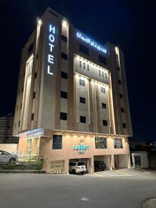 麦地那Taj Al Eiman Hotel的夜间标有标志的酒店大楼