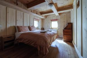 福尔马扎La WalserHus的卧室配有一张床铺,位于带木墙的房间内