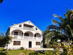 查克维Lisa's Villa in Chakvi的前面有棕榈树的白色房子