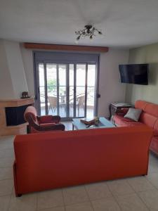 尼亚普拉莫斯Dominikis appartment的客厅配有红色的沙发和椅子