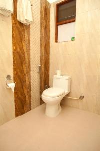 奇旺Sauraha Holiday Home Riverside的一间带白色卫生间的浴室和窗户。