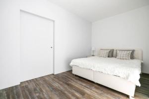 班斯卡-比斯特里察ALURE RESIDENCES 1 & 24h self check-in的白色卧室设有白色的床和木地板