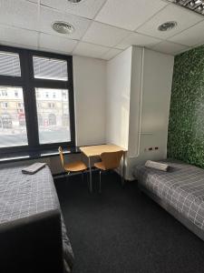华沙Aleja "Solidarności"的客房设有两张床、一张书桌和两个窗户。