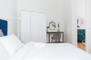 维也纳Brand Cozy Apartment的白色卧室配有白色的床和椅子