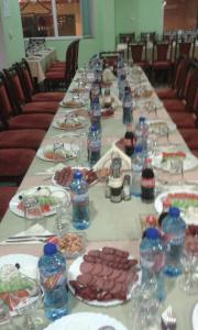 瑟尔尼察Family Hotel Panorama的一张长桌,上面放有食物和水瓶