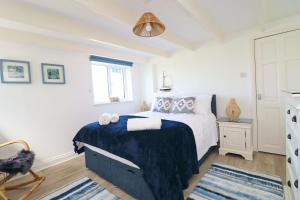 Saint ErvanCoastal retreat surrounded by open countryside的一间卧室配有一张带蓝色毯子的床