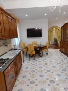 圣安吉洛钦齐亚别墅公寓的厨房配有桌子,墙上配有电视。