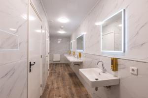 巴特纽维斯Hotel Leeuwerik的白色的浴室设有两个盥洗盆和镜子
