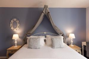圣西普里安Hotel-Restaurant des Augustins - Cosy Places by CC - Proche Sarlat的卧室配有带白色枕头的天蓬床