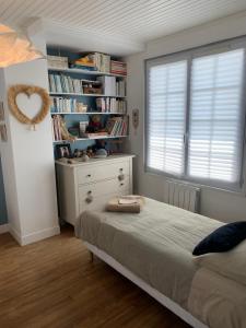 Fontaine-ÉtoupefourChez Viviane的一间卧室设有一张床和一个书架