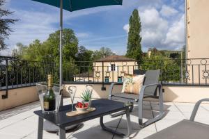 圣西普里安Hotel-Restaurant des Augustins - Cosy Places by CC - Proche Sarlat的庭院配有桌椅和遮阳伞。