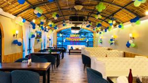 PanwāriHotel The Mewar的餐厅设有桌椅和天花板上的气球