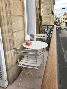 波尔多Appartement gare Saint jean的阳台上配有白色的桌椅